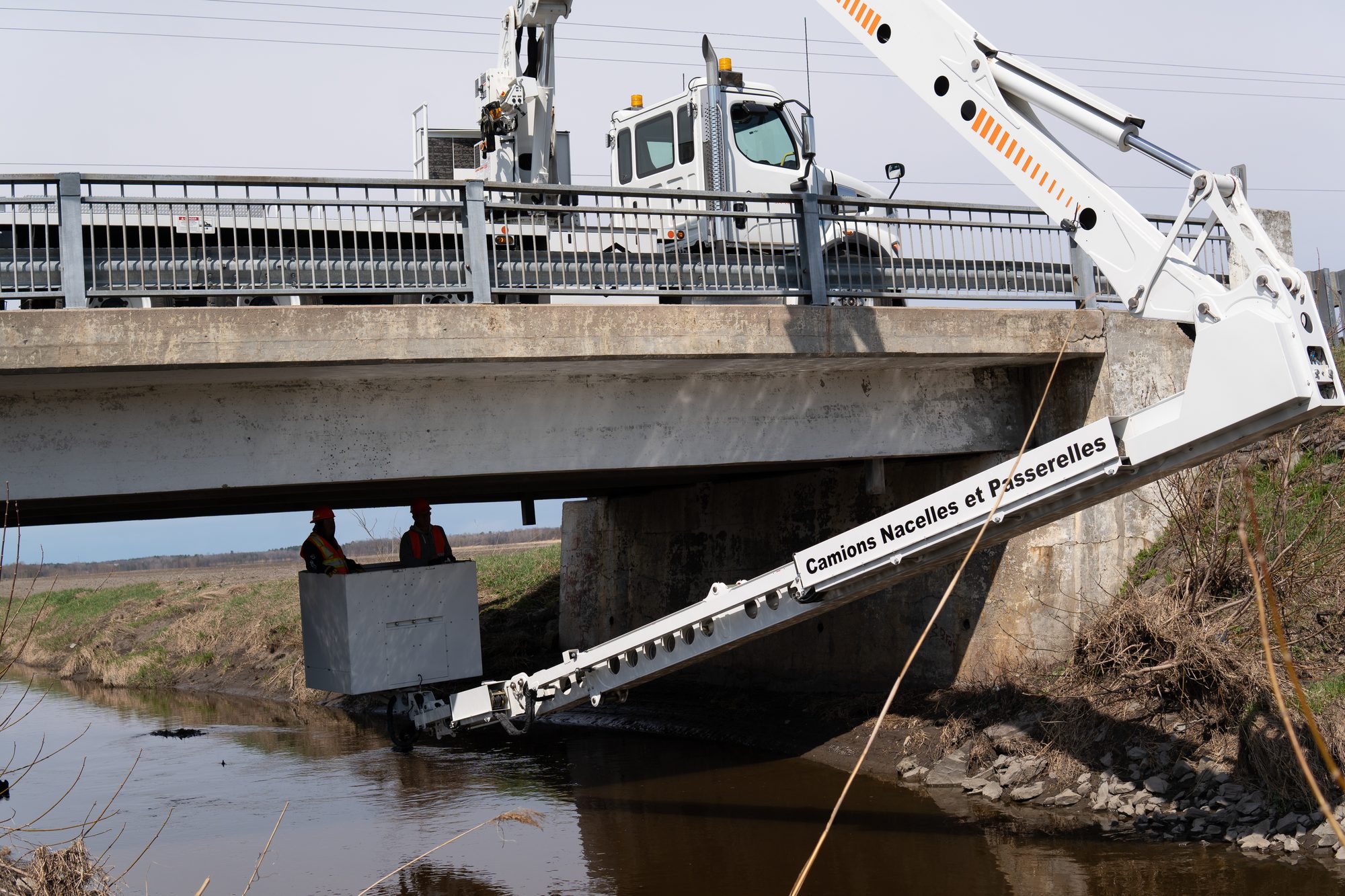Bucket boom deployed under a bridge